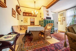 A traditional room with a dining table, chairs, a sofa, a patterned rug, a chandelier, and a green cabinet with glass doors. - 'Romantic Holiday Home' with Garden & Wi-Fi (Gerdau)