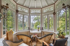 A conservatory with wicker furniture, a table, and a lamp. - 'Romantic Holiday Home' with Garden & Wi-Fi (Gerdau)