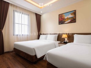 A hotel room with two beds, a large window with curtains, a painting on the wall, and a nightstand with a lamp. - Ha Long Essence Classic Hotel (Bai Chay)
