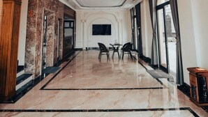 A spacious hotel lobby with marble flooring, a high ceiling with recessed lighting, and large windows. - Ha Long Essence Classic Hotel (Bai Chay)