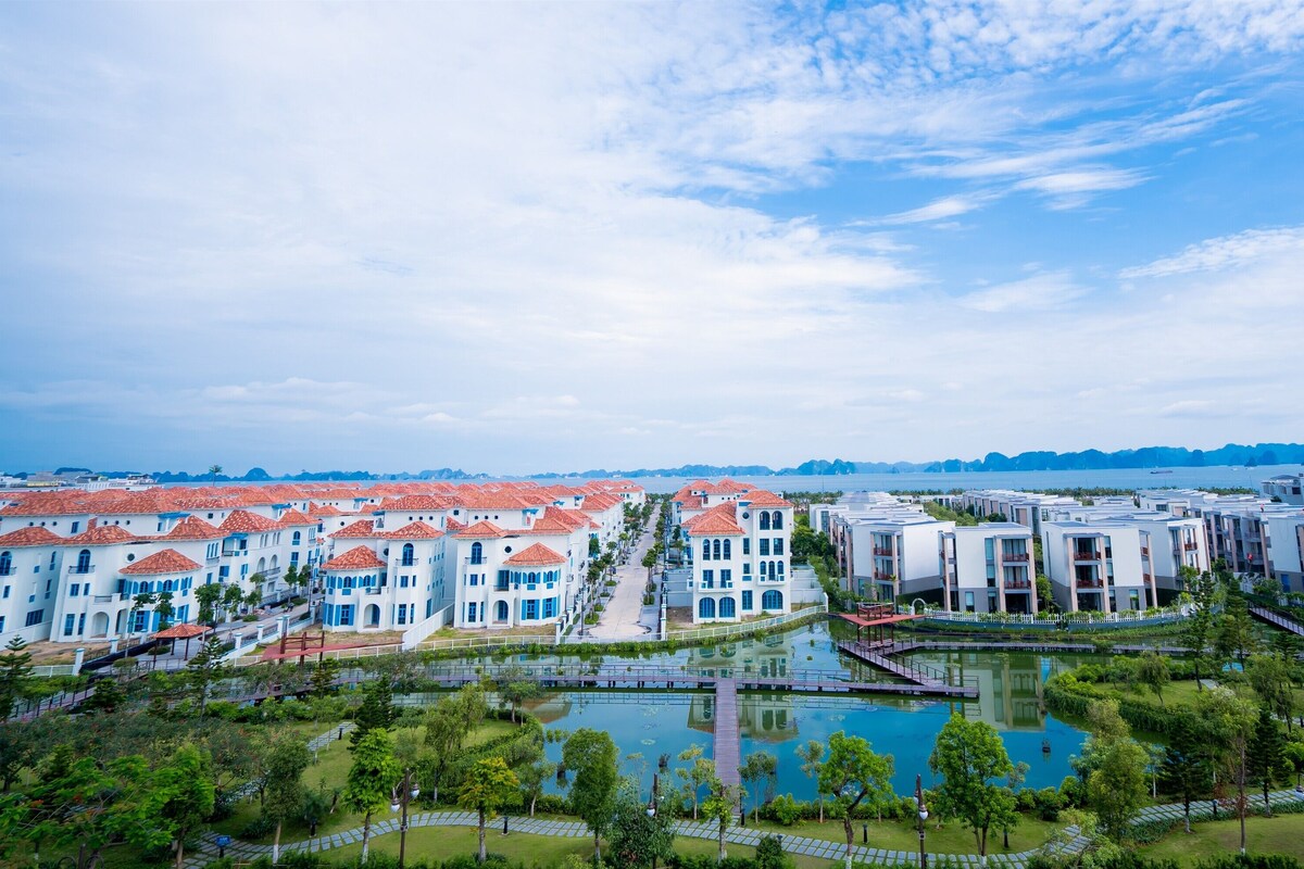A resort with multiple buildings, a central courtyard, and a body of water.