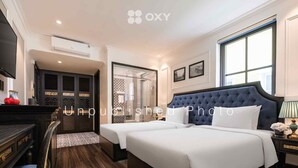 A hotel room with a large bed, a desk, and a wardrobe. - Ha Long Essence Classic Hotel (Bai Chay)