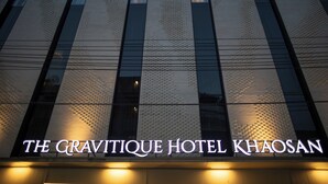 Exterior del Hotel Gravitique Khaosan, con fachada texturizada e iluminación.