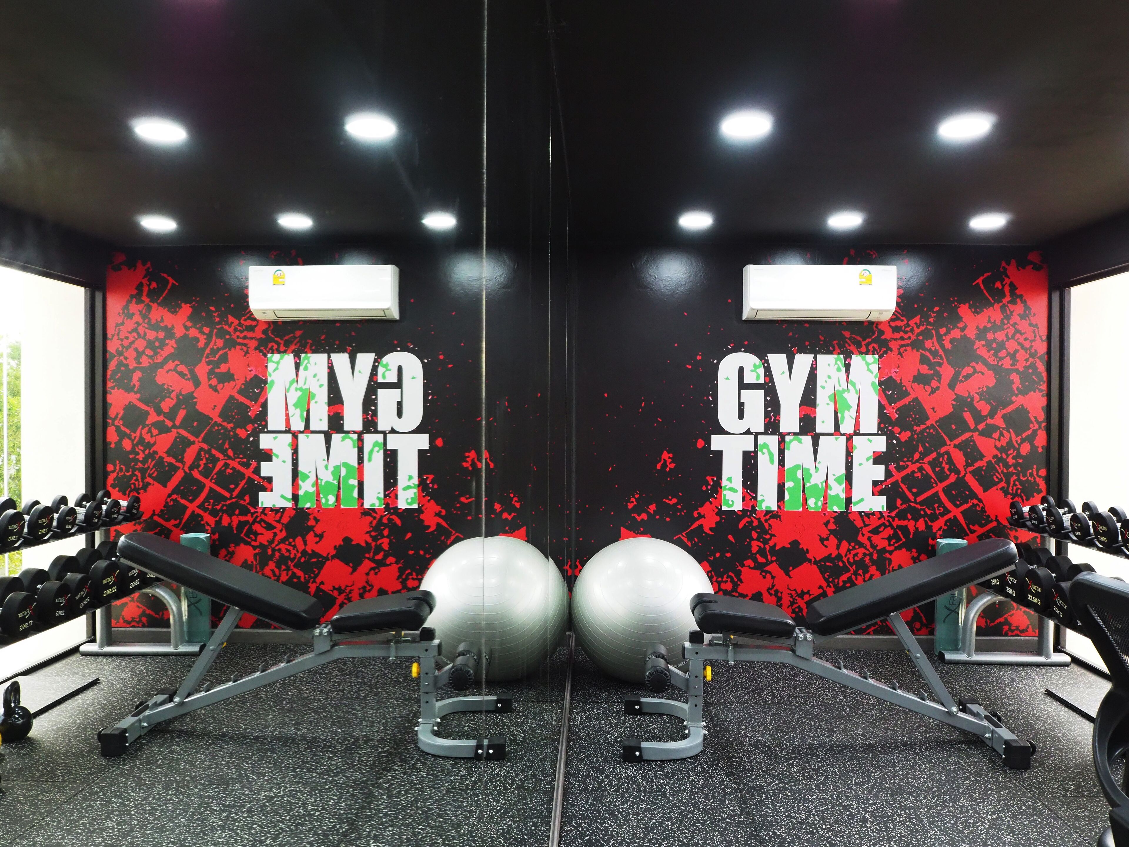 A gym with mirrored walls, exercise equipment, and motivational graffiti.