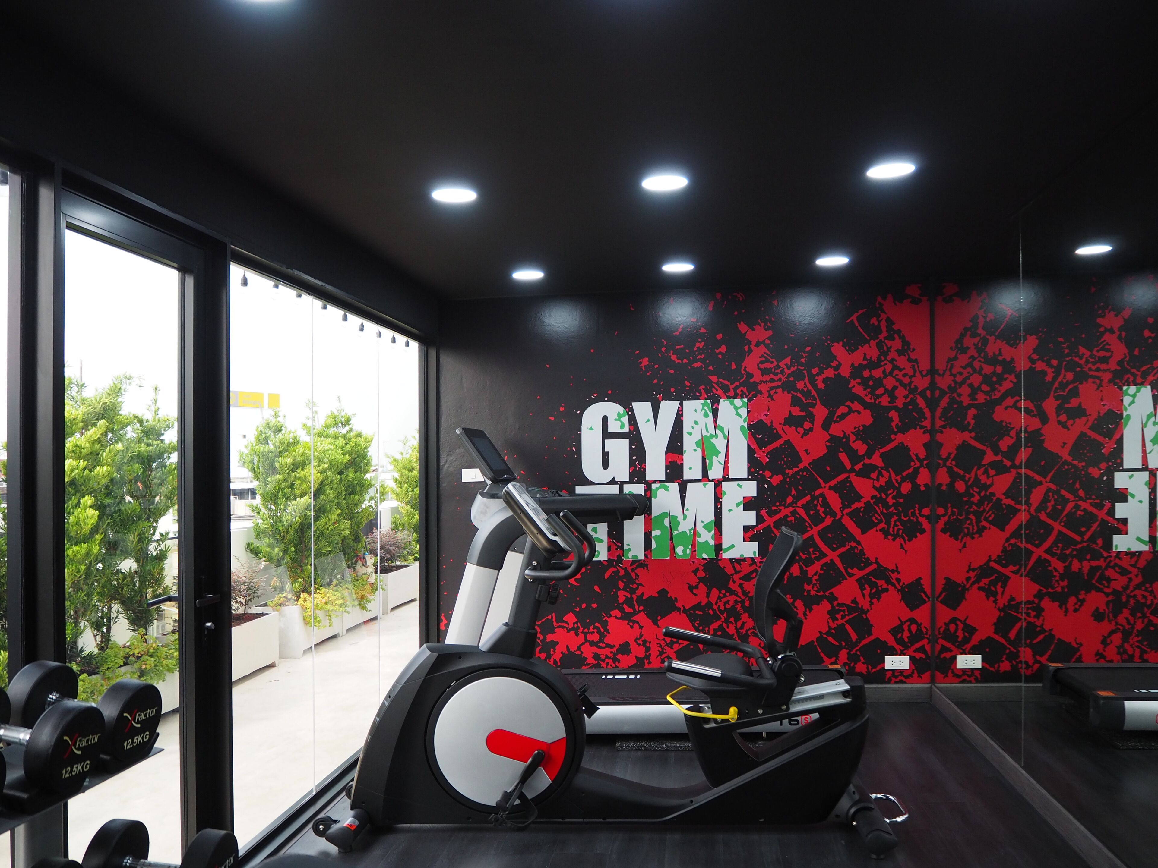 Ein Fitnessstudio mit Laufband, Gewichten und einer Wand mit Graffiti.