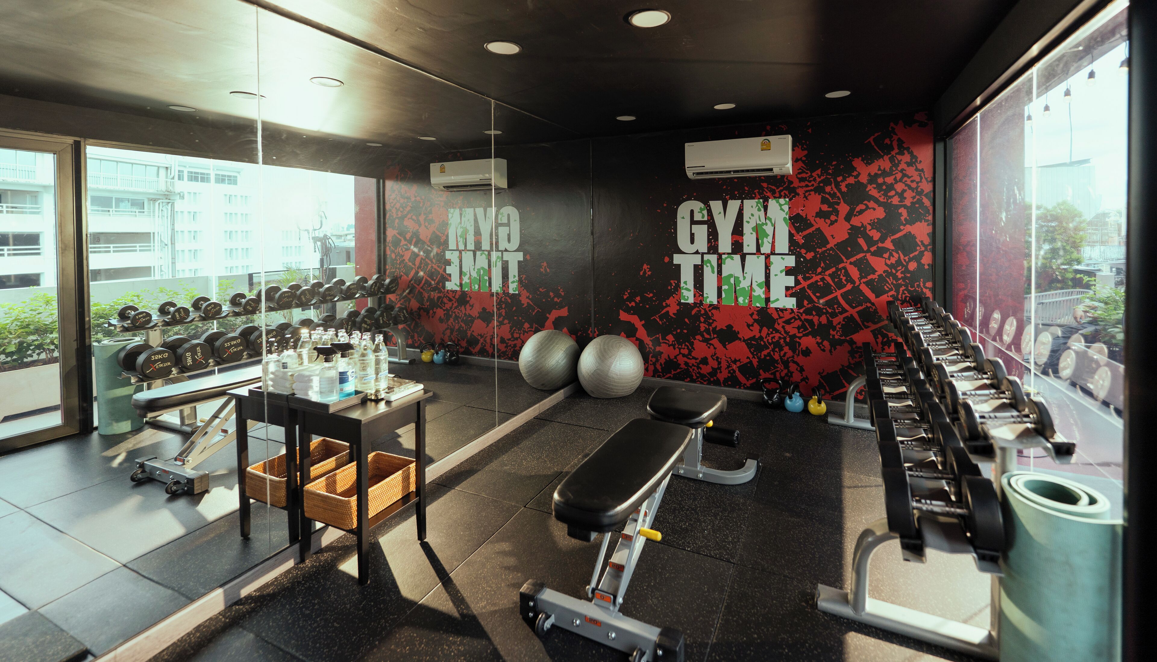 A gym with exercise equipment, a bench, and a wall with motivational text.