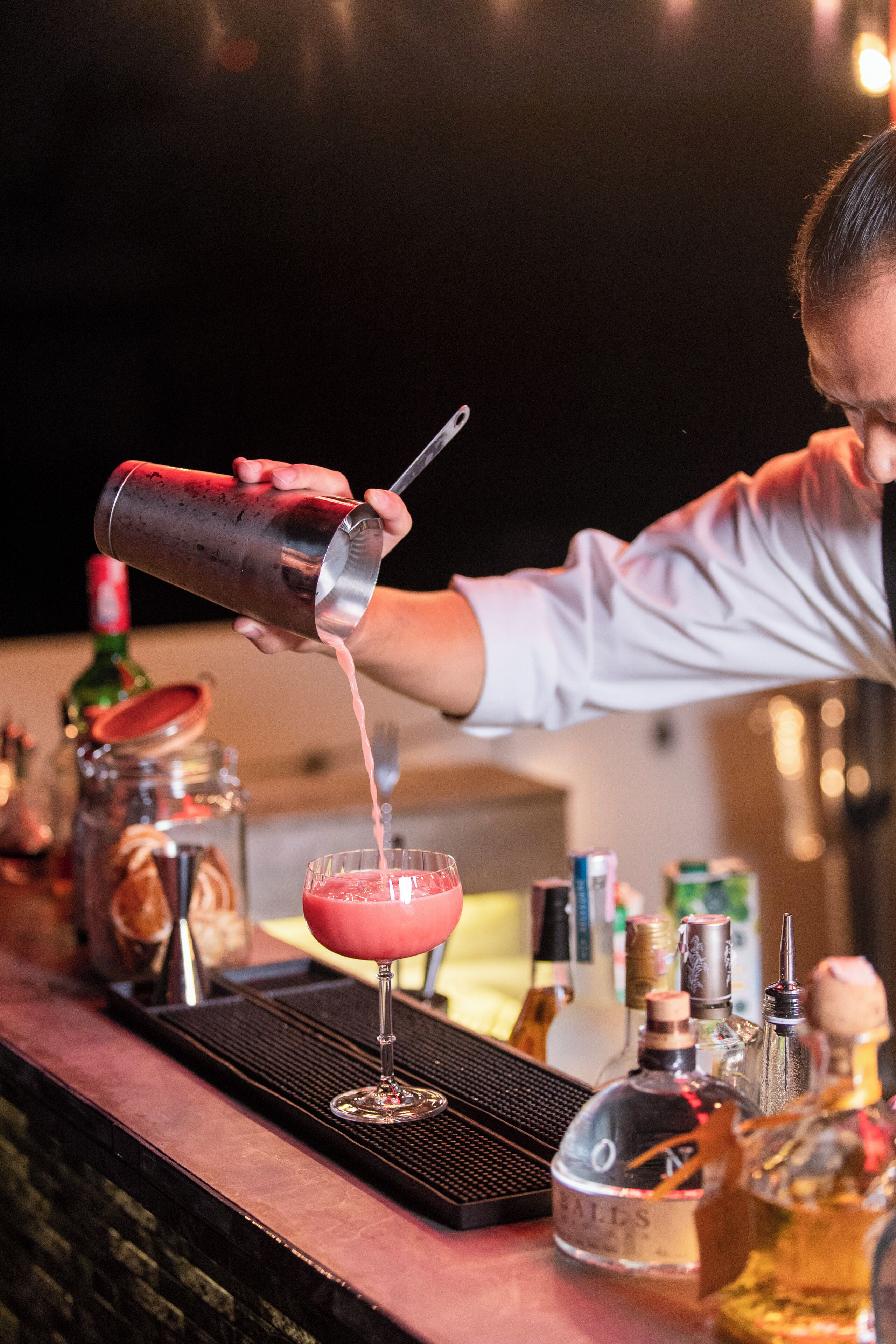 Een barman schenkt een drankje in.