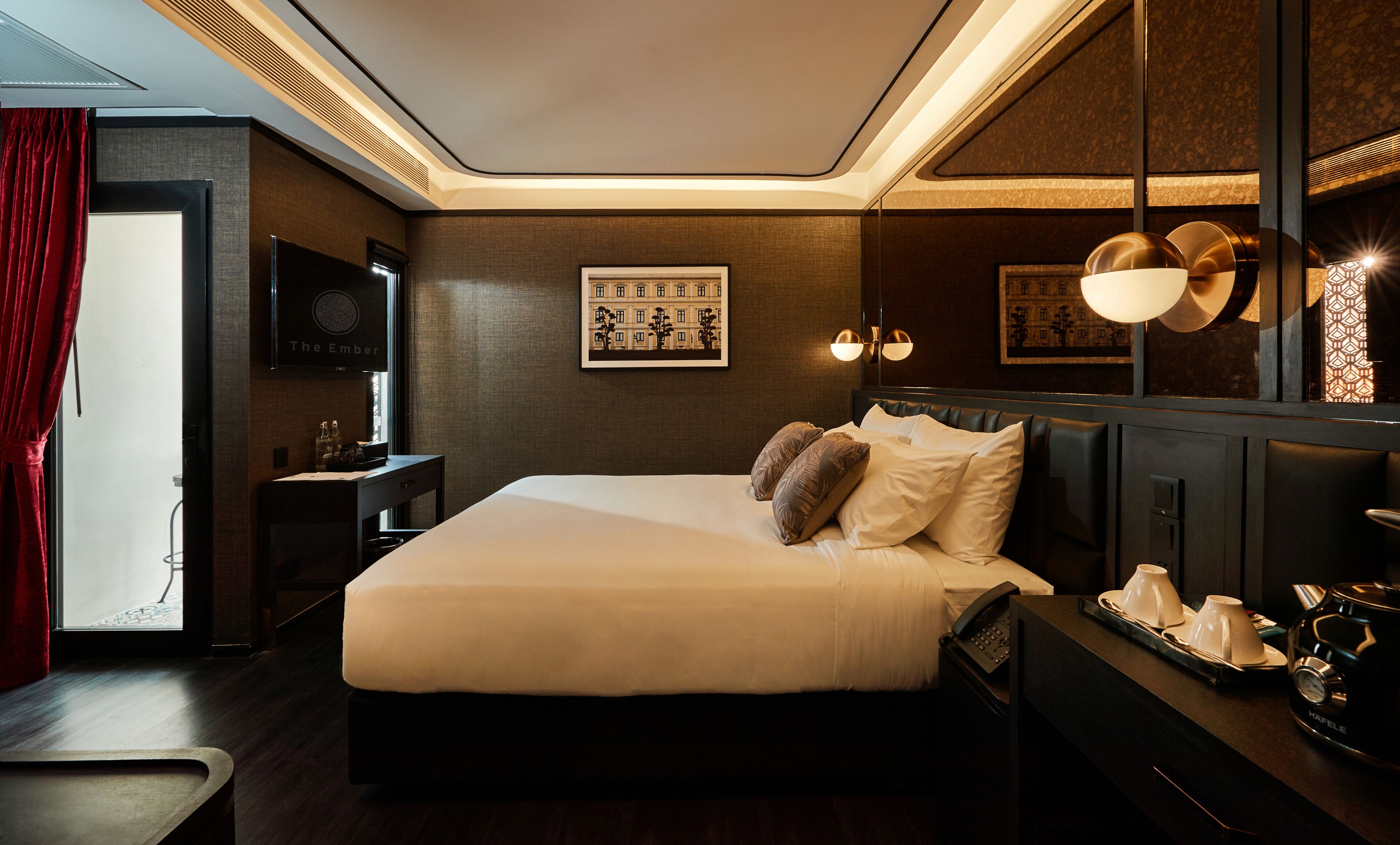 Ein Hotelzimmer mit einem großen Bett, einem Nachttisch mit Lampe, einem Spiegel und einem gerahmten Bild an der Wand.