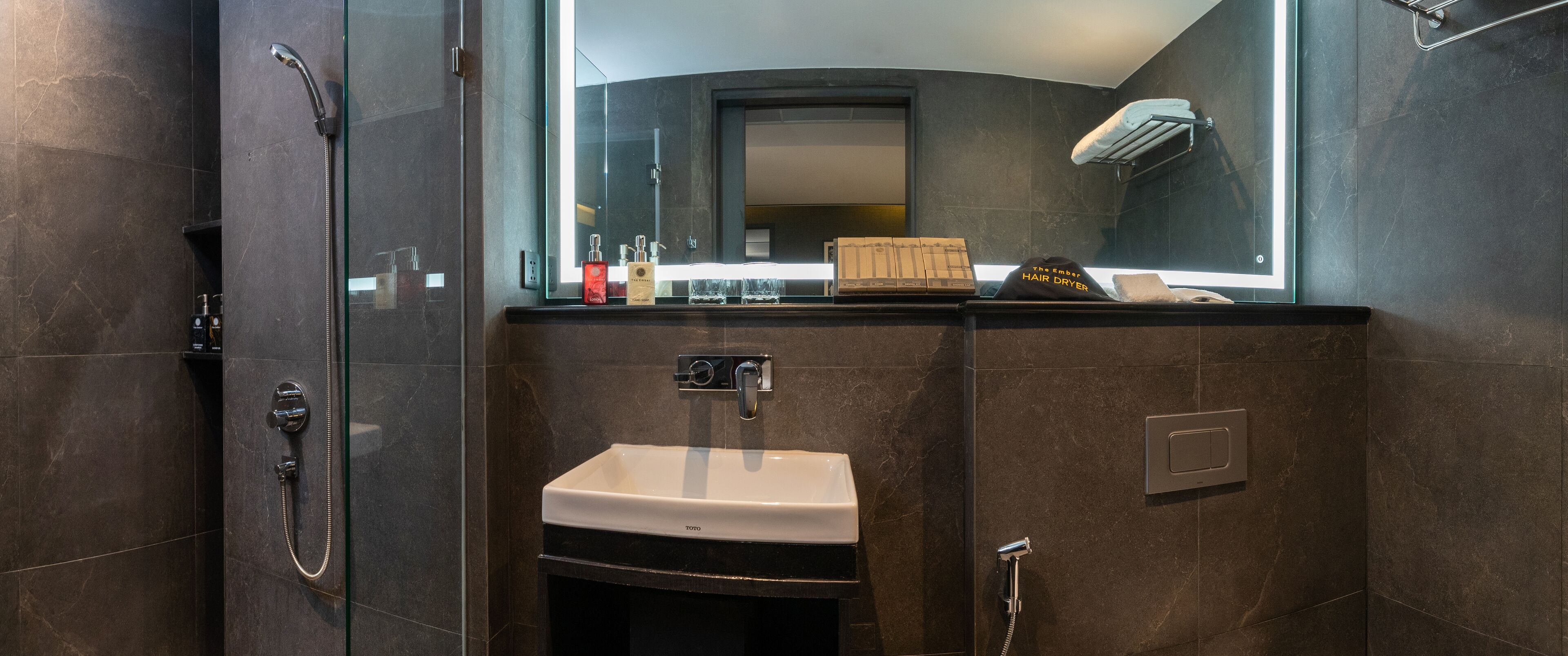 A modern bathroom with a glass-enclosed shower, a white sink, and a mirror above the sink.
