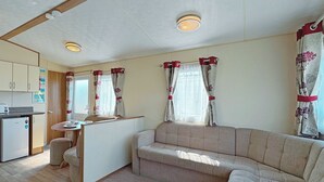 A compact living space with a kitchenette, a sofa, and a dining area.