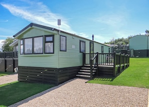 A single-story mobile home with a front porch and a small set of stairs leading to the entrance. - Comfortable and spacious 12ft-wide caravan with one double and one twin. (Slaley, Hexham)