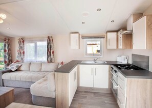 A compact kitchen with a built-in stove, a sink, and a window above the countertop. - The Maple is designed to give you an all inclusive spec at an affordable price. (Tenbury Wells)