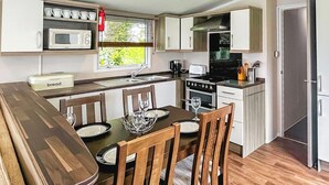 Eine kompakte Küche mit Essbereich, ausgestattet mit Mikrowelle, Toaster und Herd.
