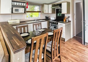 Cocina compacta con zona de comedor, equipada con microondas, tostadora y estufa.