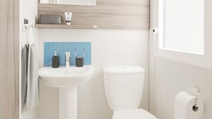 Un bagno con un lavandino bianco, un water e un portasciugamani.