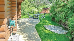 A wooden cabin with a patio, outdoor furniture, and a garden. - 2 bedroom accommodation in Craobh Haven, Argyll (Craobh Haven, Argyll)