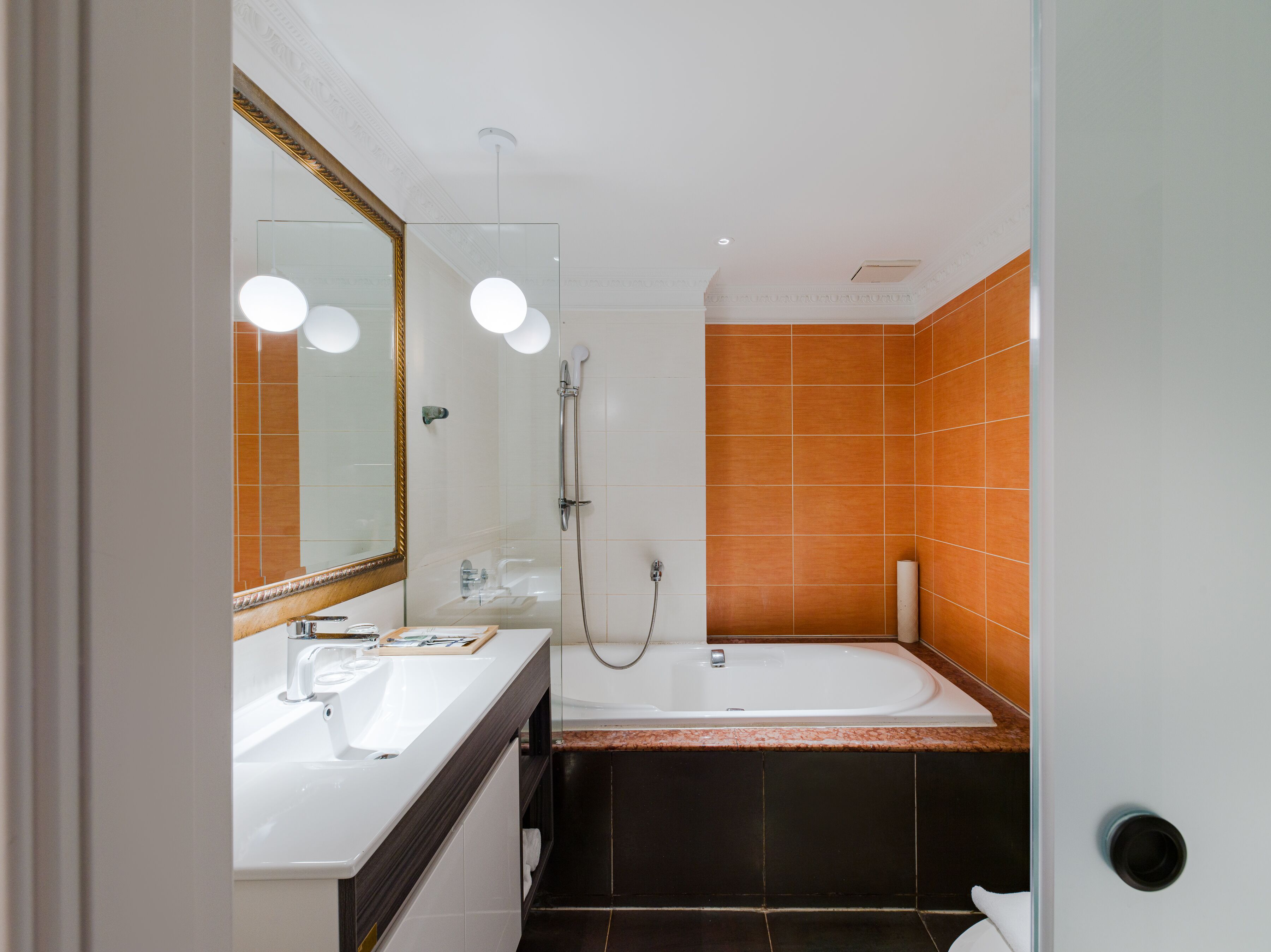 A modern bathroom with a double sink, a large mirror, and a shower area.