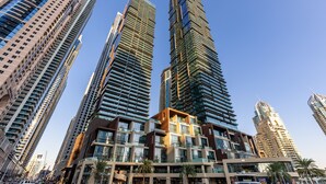 A high-rise building with multiple floors, large windows, and a modern architectural design. - Maison Privee - Exclusive Apt w/ Striking Sea & Dubai Marina Vws (Dubai)