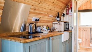 A compact kitchen with wooden cabinets, a stainless steel kettle, a toaster, and a sink. - 1 bedroom accommodation in Troutbeck (Troutbeck)