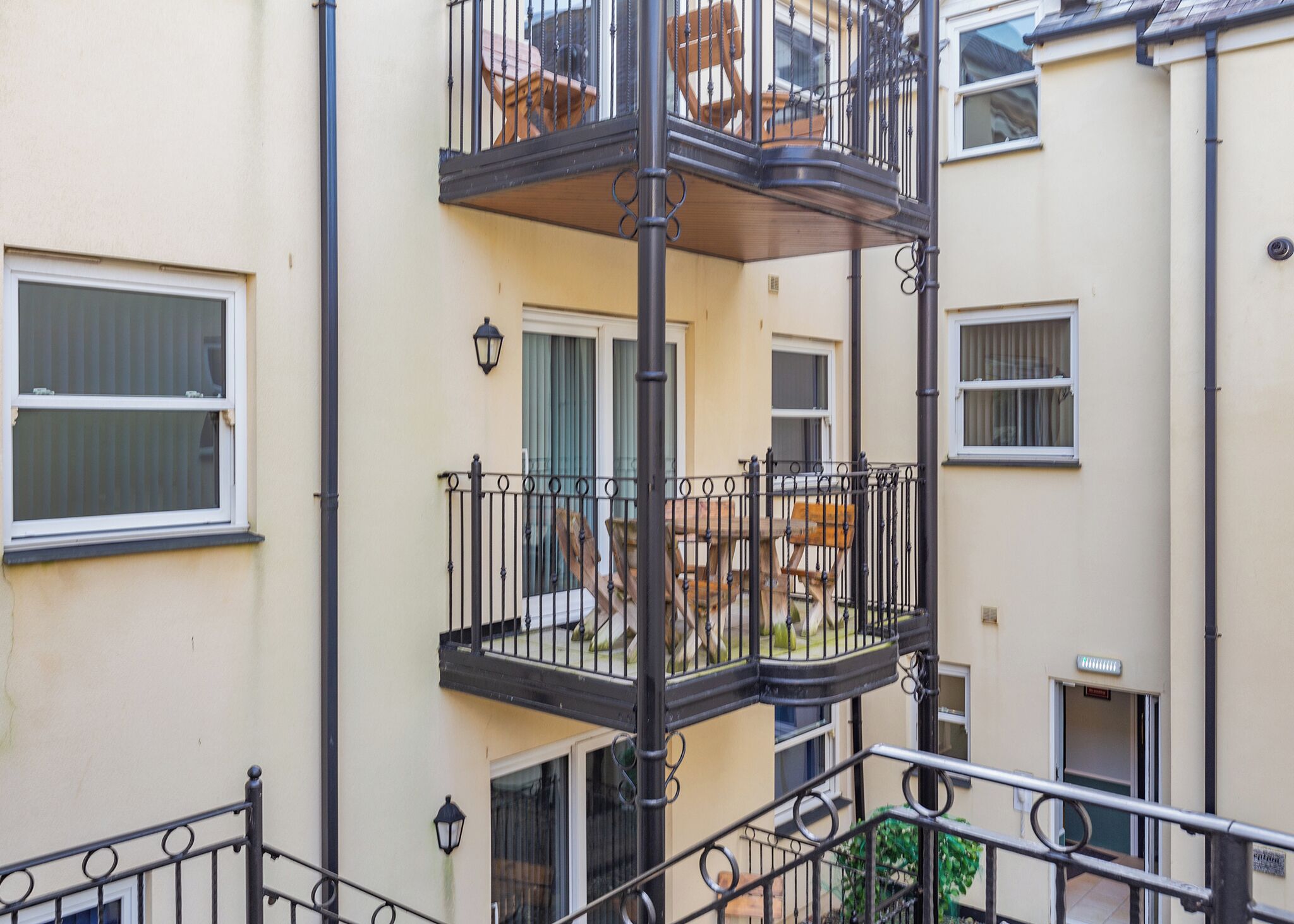 Un edificio de varios pisos con balcones, barandillas y ventanas.