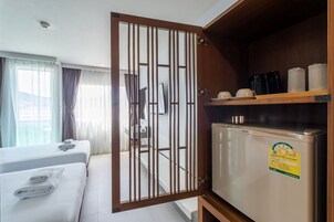 Une chambre d’hôtel équipée d’un lit, d’un minibar, d’un réfrigérateur et offrant une vue sur l’extérieur.
