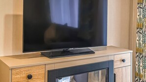 A television on a wooden cabinet with a built-in fireplace.