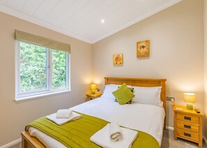 A bedroom with a bed, two bedside lamps, a window, and two wall art pieces. - 2 bedroom accommodation in Cartmel (Cartmel)