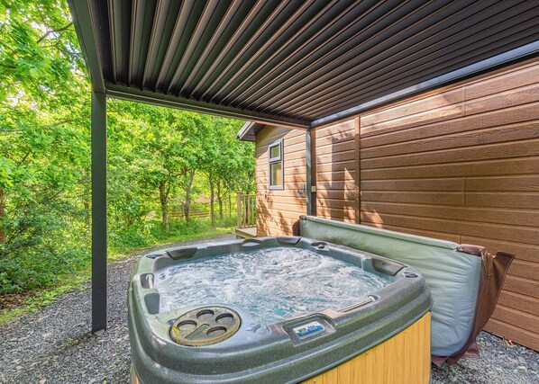 A hot tub under a wooden pergola with a wooden cabin in the background. - 1 bedroom accommodation in Cartmel (Cartmel)