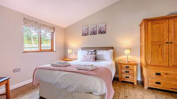 A bedroom with a bed, bedside tables, a wardrobe, and a window.
