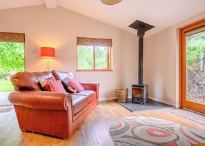 A living room with a leather sofa, a fireplace, and a large window.