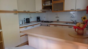 Una cocina moderna con armarios blancos, una isla central y un lavamanos.