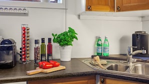 A kitchen with a built-in stove, a sink, and a window with a potted plant. - Krokenskogen (Sandefjord)