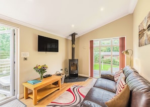 A living room with a sofa, a television, a fireplace, and a large window.