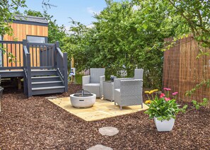 A backyard with a wooden play structure, outdoor furniture, and a garden area. - Brand new for 2021 is this stunning open plan modern hotel suite lodge. (Moortown)