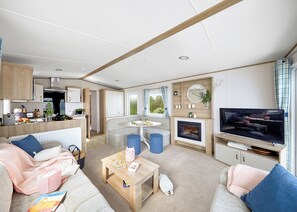 A compact living space with a kitchenette, seating area, and a television.