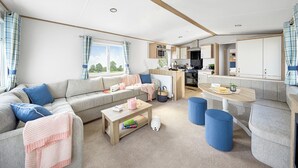 Ein moderner, gut beleuchteter Wohnbereich mit Sofa, Couchtisch und Esstisch.