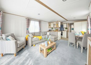 A modern living room with a sofa, coffee table, and dining area.