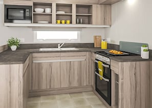 Eine moderne Küche mit Holzschränken, einer eingebauten Mikrowelle, einem Herd und einem Spülbecken.