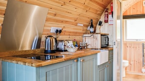 A compact kitchen with wooden cabinets, a stainless steel kettle, a toaster, and a sink. - 1 bedroom accommodation in Troutbeck (Troutbeck)