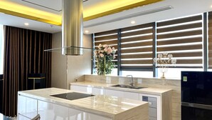 Una cocina moderna con una isla central, electrodomésticos de acero inoxidable y un jarrón decorativo.