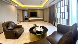 Una sala de estar moderna con un televisor de pantalla plana, una mesa de centro con objetos decorativos y sofás de cuero.