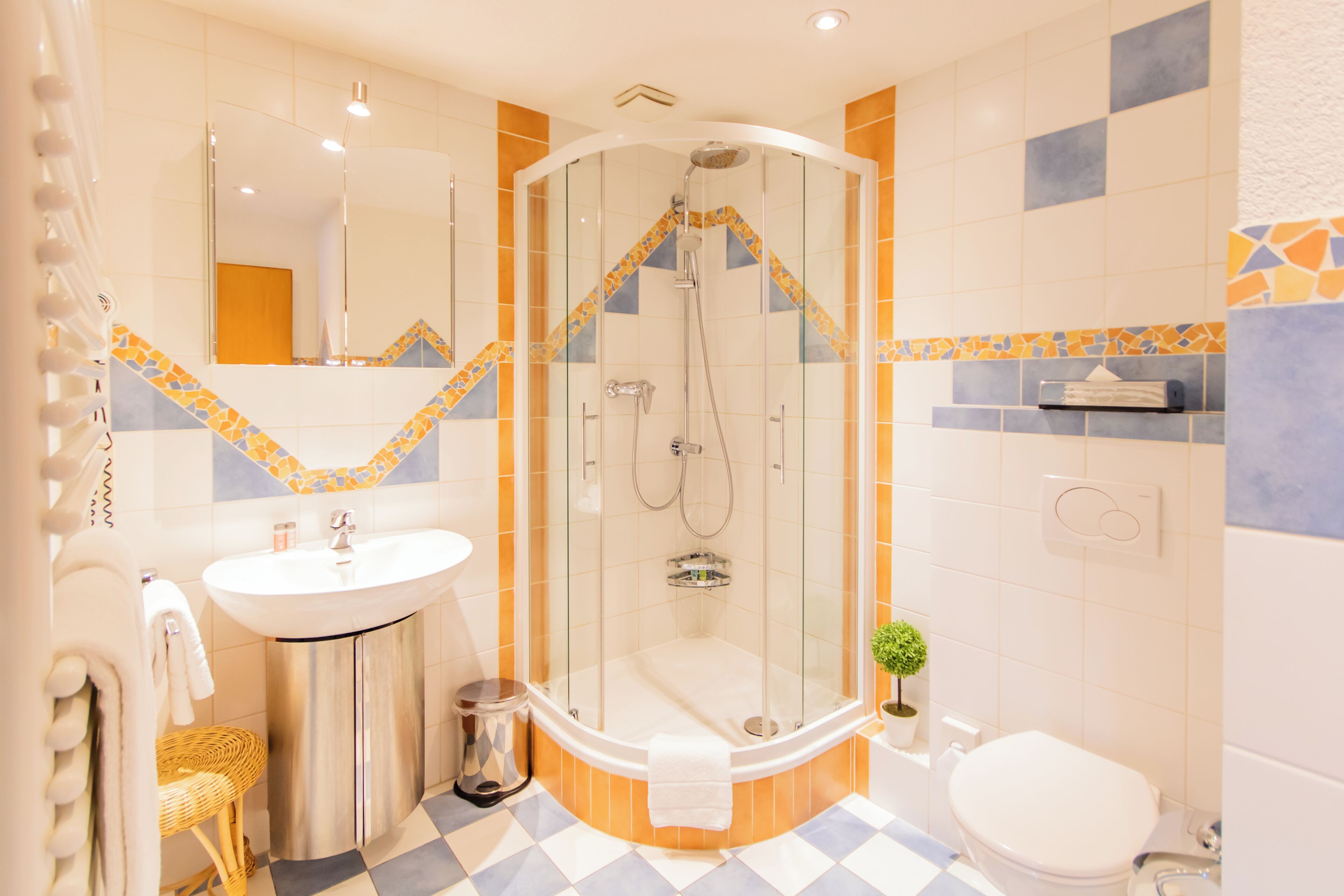 A modern bathroom with a glass-enclosed shower, a sink, and a toilet.