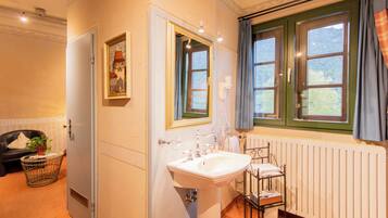 Une salle de bain avec un lavabo, un miroir et des fenêtres.