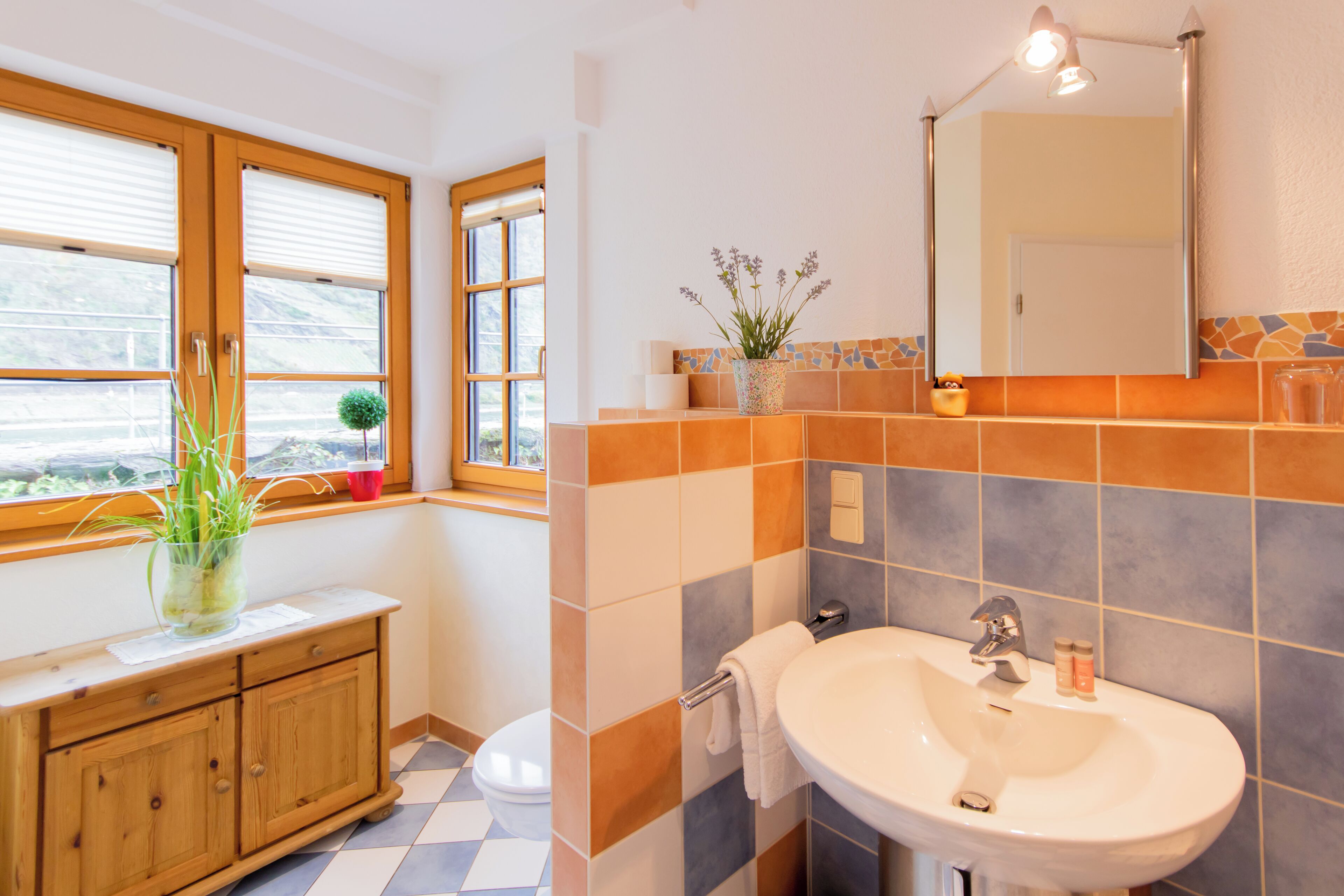 A bathroom with a sink, mirror, and window.