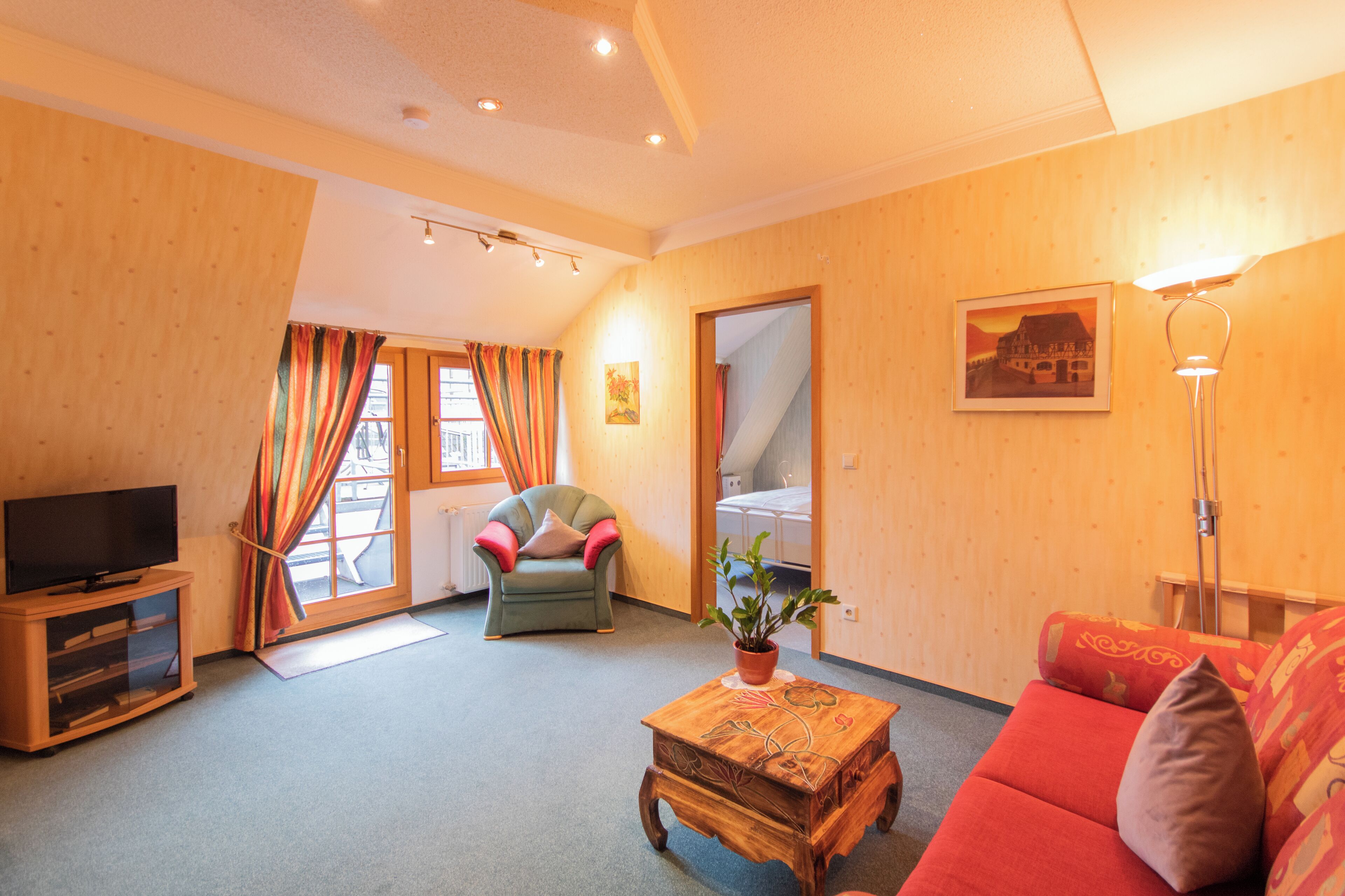 Una sala de estar acogedora con televisor, sofá, sillón y una mesa de centro.