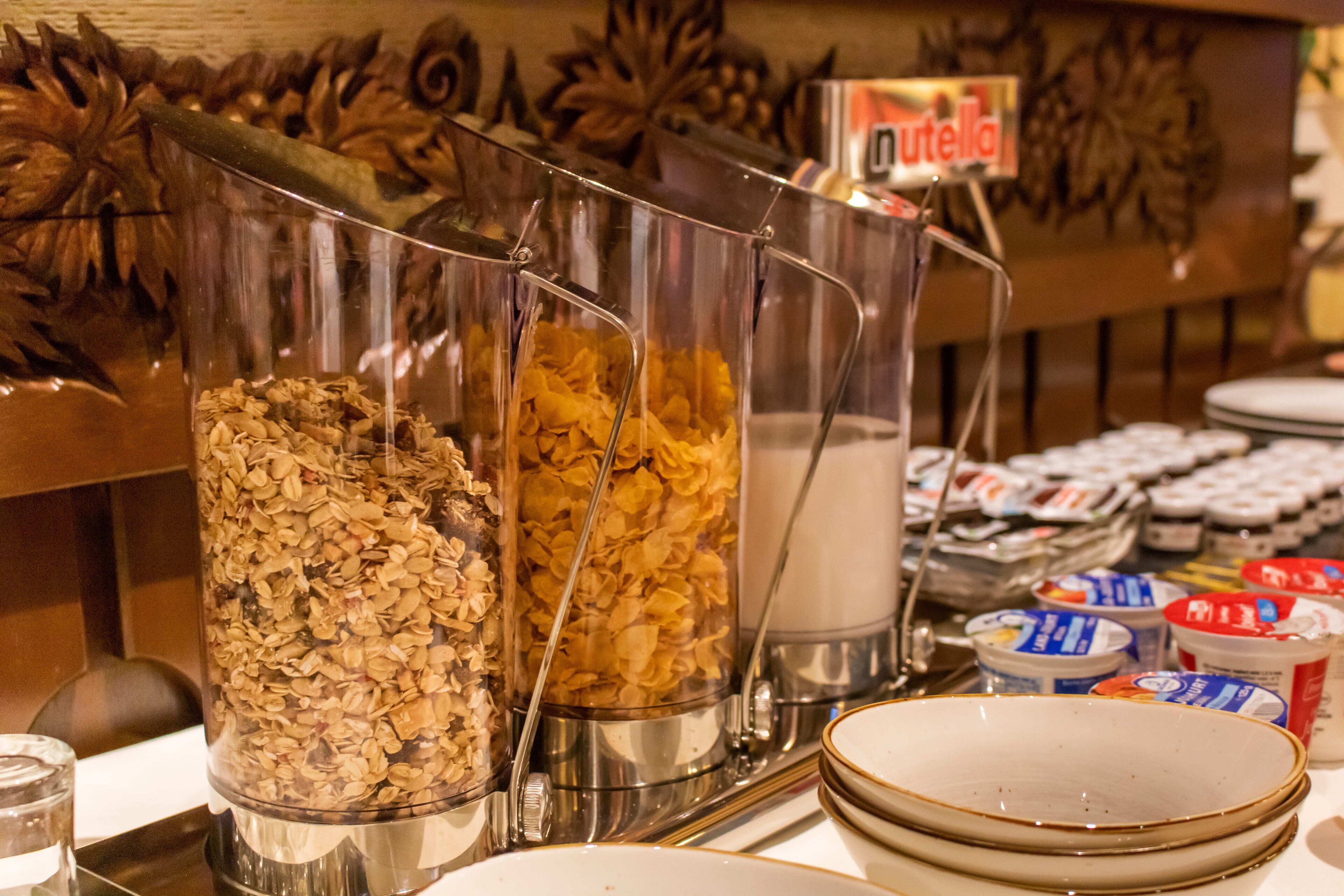 A buffet with various food items including cereals and spreads.