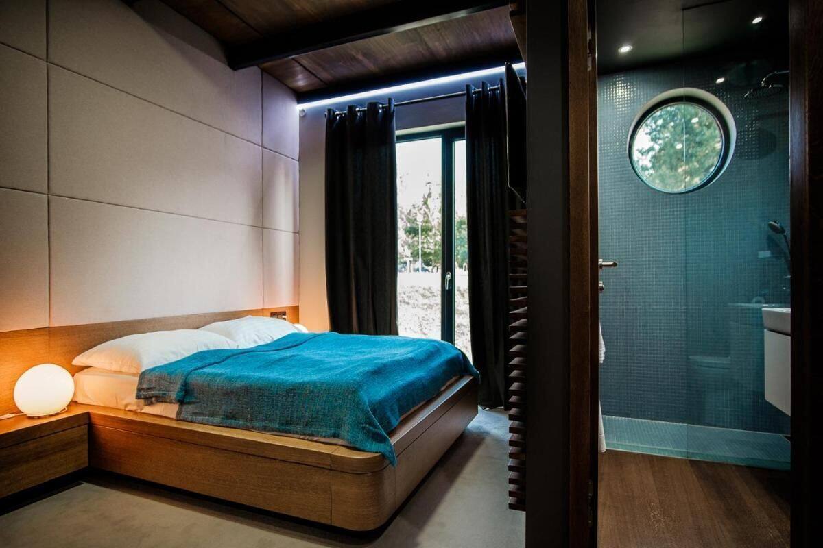 A modern bedroom with a bed, bedside table, and a view of a bathroom.