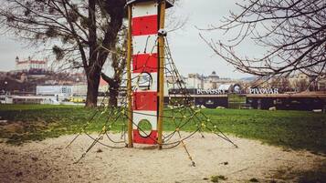 A red and white striped pole with yellow ropes in a park.