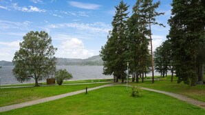 Un parc doté d’une allée pavée, d’arbres et d’un lac.