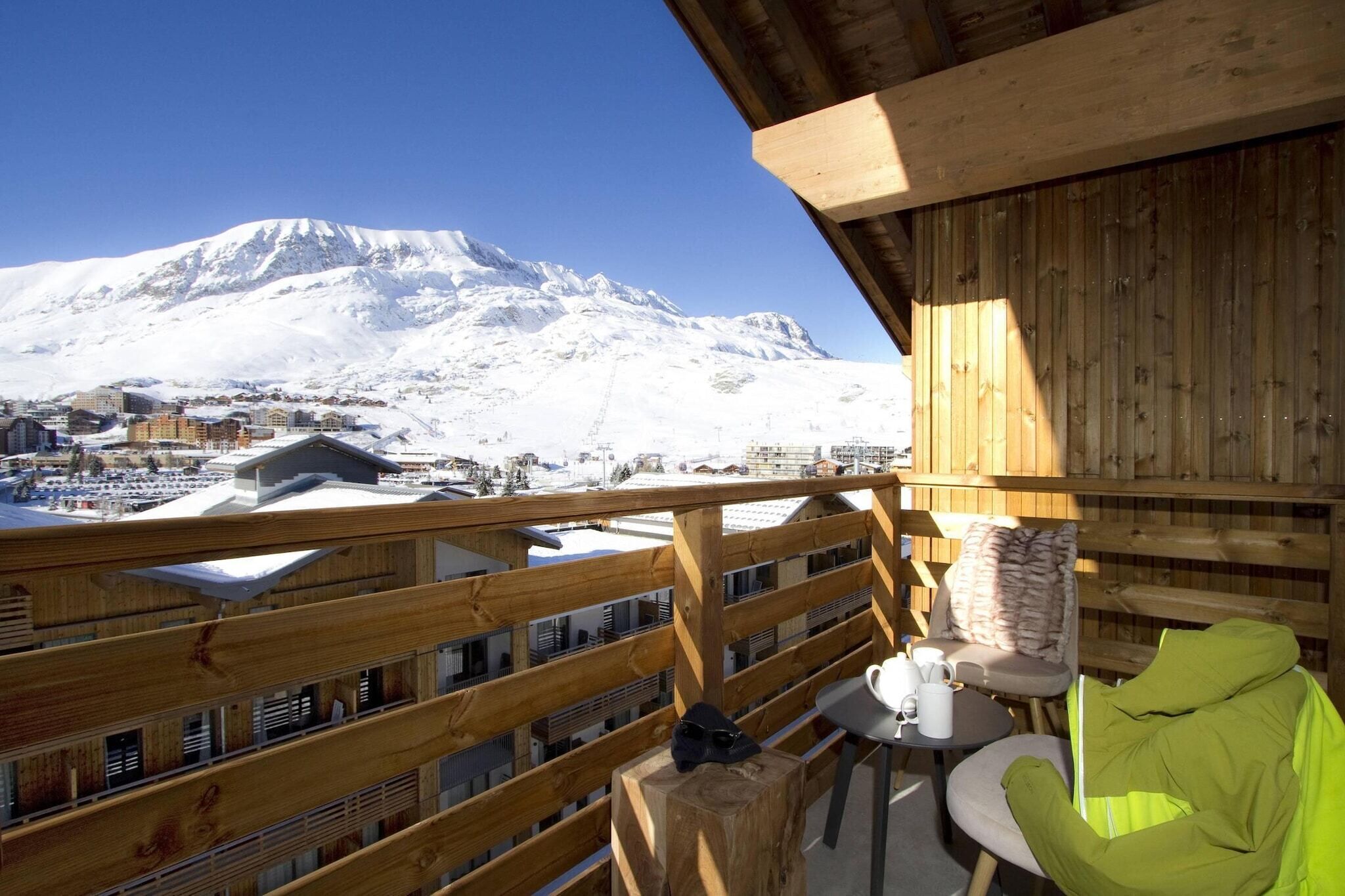 Un balcon en bois offrant une vue sur une montagne enneigée.